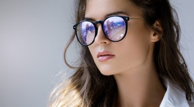 close-up-portrait-young-woman-with-reflection-modern-city-inside-eyeglasses